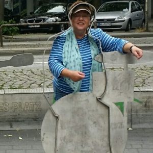 Touristin steht bei Stadtführung vor Metallskulptur in Hamburg