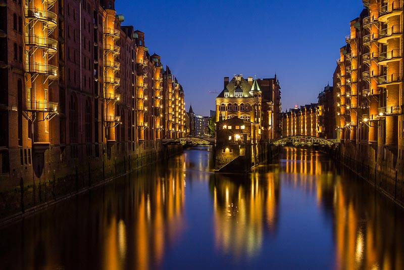 Speicherstadt Hamburg bei Abenddämmerung mit Kanal und Lichtern